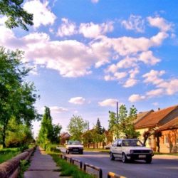 Row of houses next to a road with cars on it