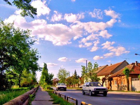 Row of houses next to a road with cars on it